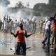 A supporter of Gabonese opposition leader Jean Ping prays in front of security forces.